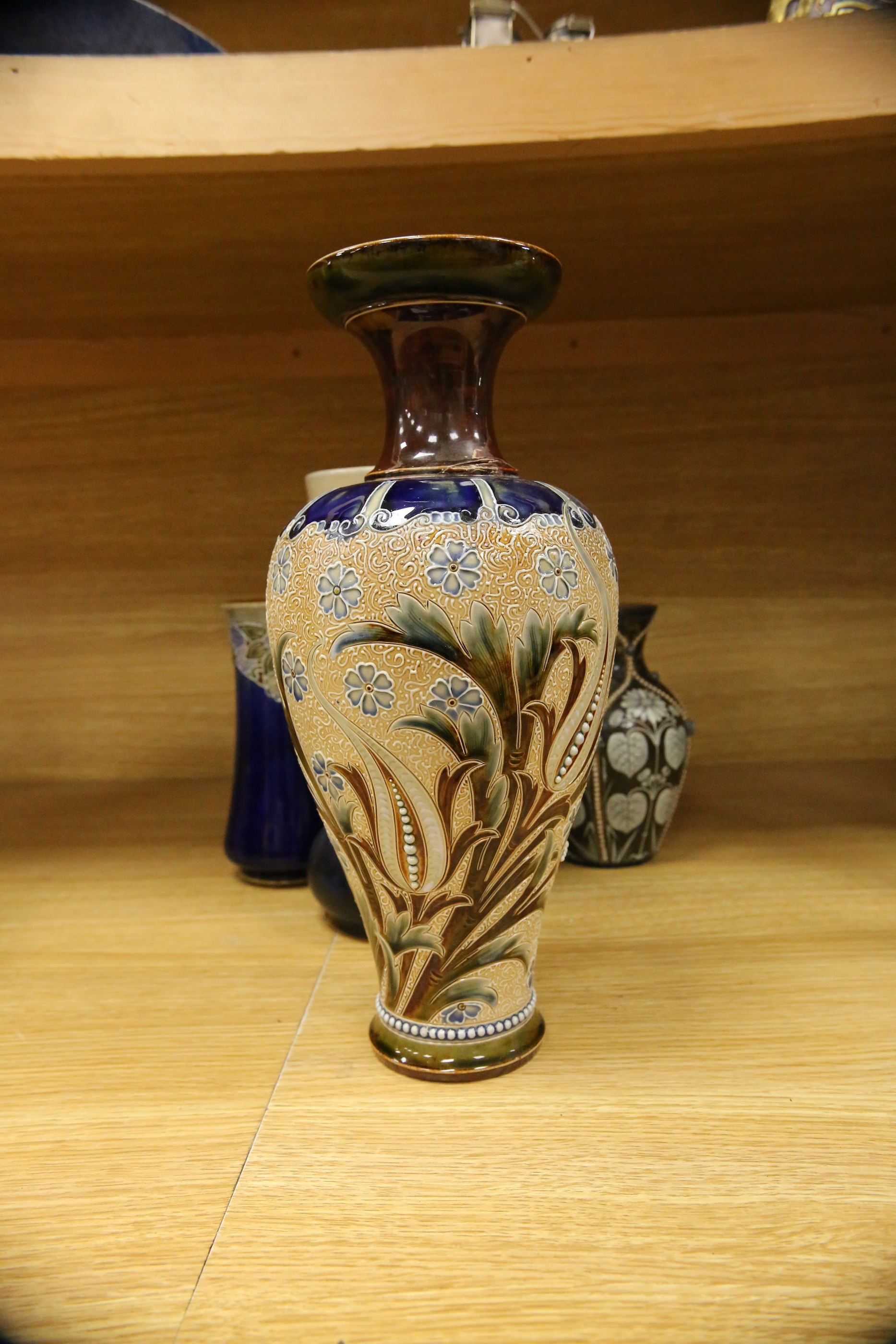 Four Royal Doulton vases and a yellow glazed jug items, tallest vase 34cm high. Condition - some crazing and faults, large vase has damage to lower neck